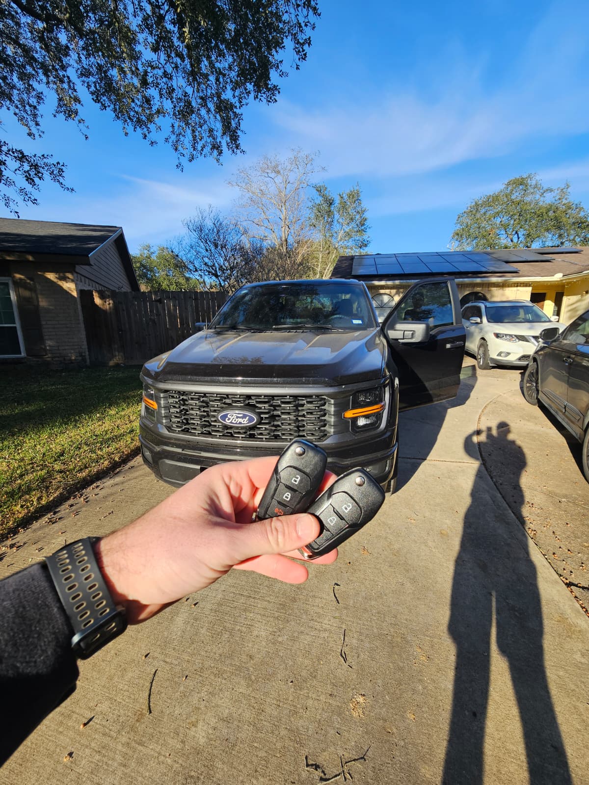 Ford F-150 key replacement at customer driveway , two new key fobs held in hand