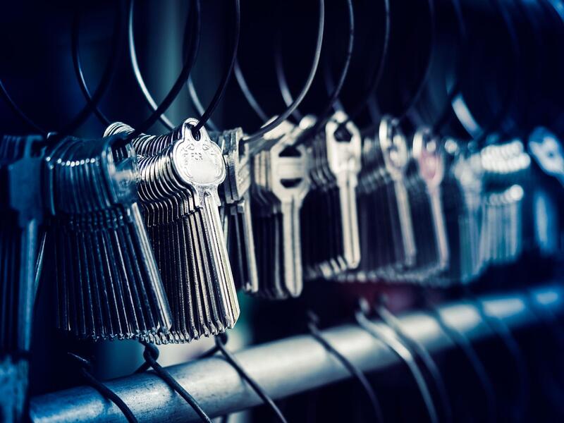 Rows of uncut key blanks hanging on rings on a rack