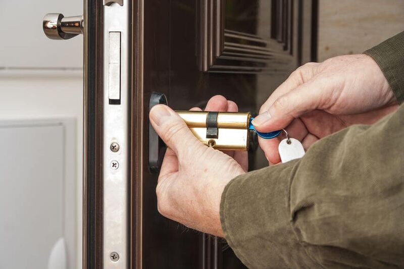 Close view of hands swapping out a corrosion-prone lock cylinder
